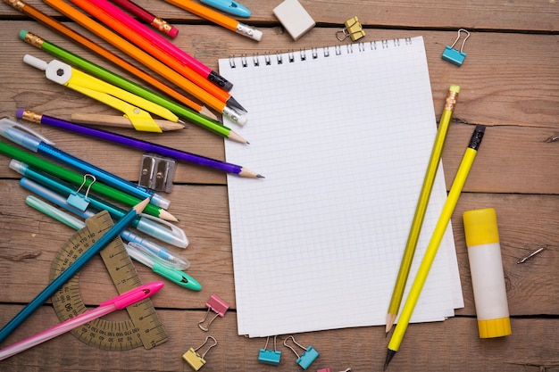 Photo Étudiant de crayons et de stylos avec un cahier sur une surface en bois