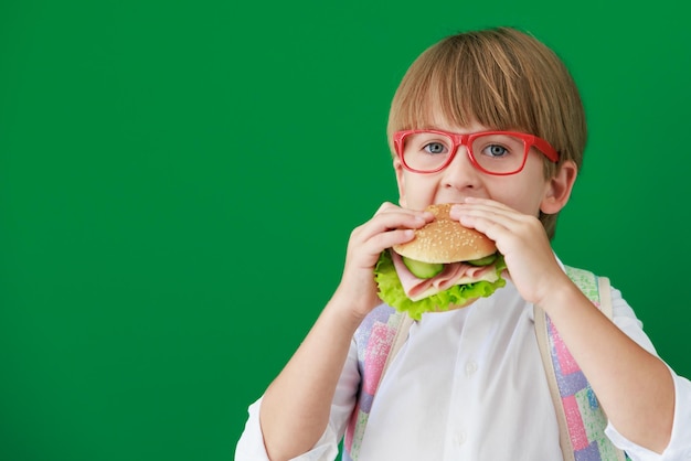 Étudiant enfant heureux contre tableau vert