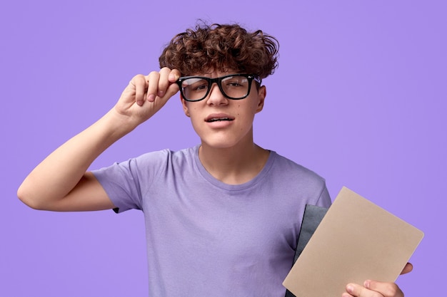 Photo Étudiant étrange avec le bloc-notes portant des lunettes