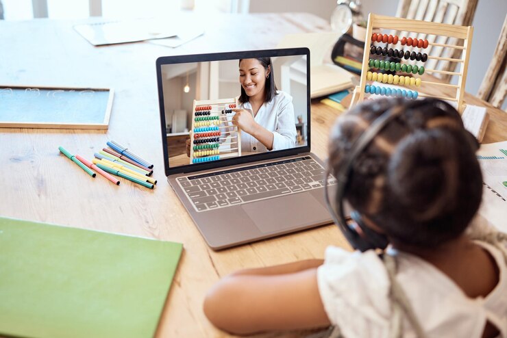 Photo un étudiant étudie en ligne avec un ordinateur portable et apprend le comptage des mathématiques et les nombres avec un professeur numérique abacus de cours en ligne et un enfant écoutant une conférence sur un casque sur une table de salon
