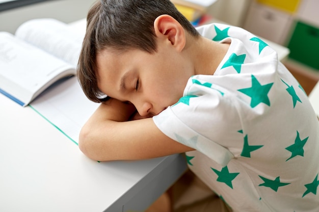 un étudiant fatigué qui dort sur la table à la maison