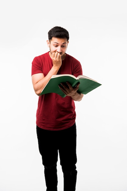 Étudiant Indien Avec Livre, Lecture Ou Montrant La Coupe De La Victoire, Récompense En Se Tenant Isolé Sur Fond Blanc