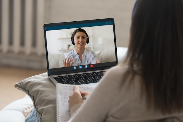 Un étudiant indien s'entretient avec un collègue universitaire, étudie, se prépare à un examen ensemble, utilise un appel vidéo, regarde l'écran d'un ordinateur portable sur l'épaule d'une femme, participe à un webinar, étudia, utilise le concept de tuition technologique moderne.