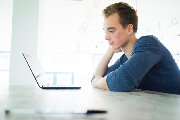 Étudiant inquiété regardant l'ordinateur portable