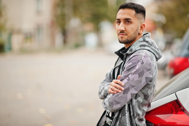 Un étudiant koweïtien porte un sweat à capuche près de la voiture