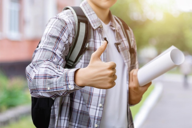 L'étudiant montre bien la main sur un arrière-plan flou