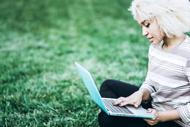 Étudiant en plein air sur l&#39;herbe avec l&#39;ordinateur portable