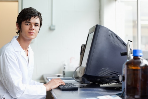 Photo Étudiant posant avec un moniteur