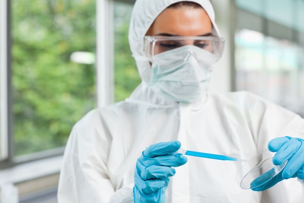 Étudiant Protégé De La Science Féminine Laissant Tomber Le Liquide Bleu Dans Un Petri