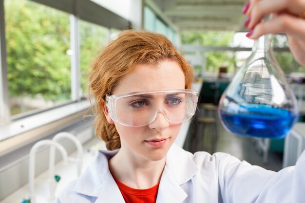 Photo Étudiant en sciences regardant une fiole