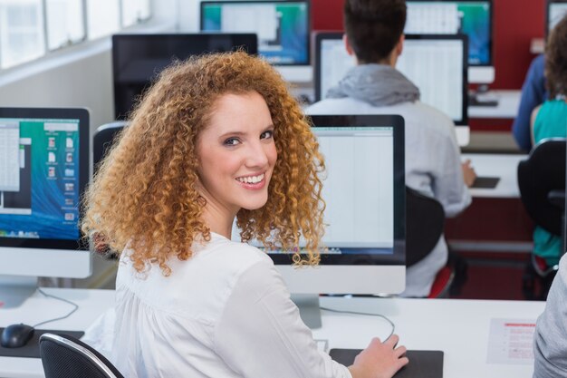 Photo Étudiant souriant à la caméra en cours d'informatique