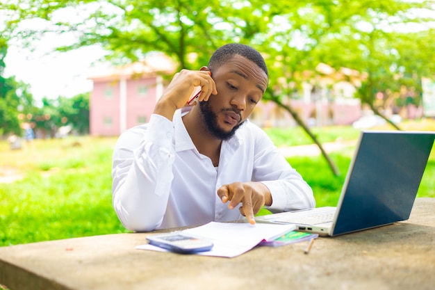 Étudiant Souriant Utilisant Un Téléphone Portable à L'extérieur