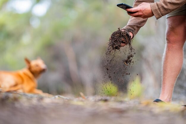 Photo Étudiant universitaire effectuant des recherches sur la santé des forêts agriculteur recueillant des échantillons de sol dans un tube à essai dans un champ agronomiste vérifiant le carbone du sol et la santé des plantes dans une ferme en australie