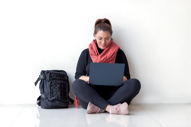 Photo un étudiant universitaire travaille sur un ordinateur portable assis sur le sol