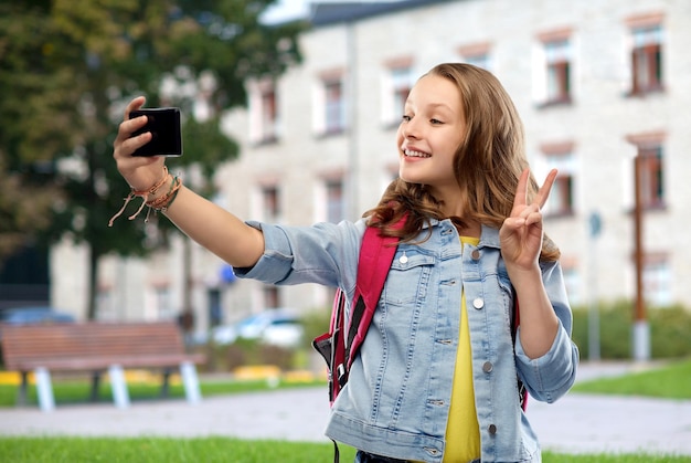 une étudiante adolescente prenant un selfie avec son smartphone