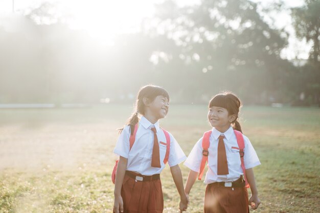 Une étudiante asiatique heureuse d'école primaire marche ensemble