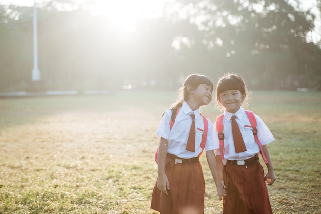 Une étudiante asiatique heureuse d'école primaire marche ensemble