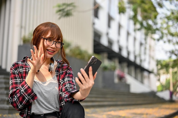 Une étudiante asiatique joyeuse a parlé avec ses amis par appel vidéo