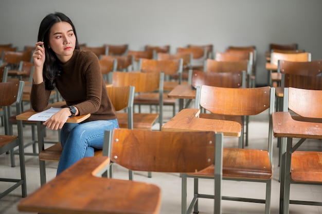 Une étudiante assise dans une classe stressante