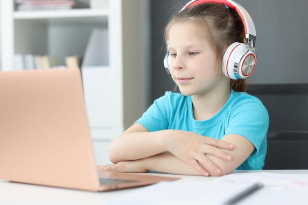 Une étudiante au casque est assise devant un ordinateur portable