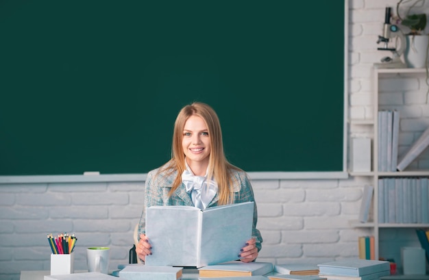 Étudiante lisant un livre sur la leçon dans la salle de classe d'une école collégiale