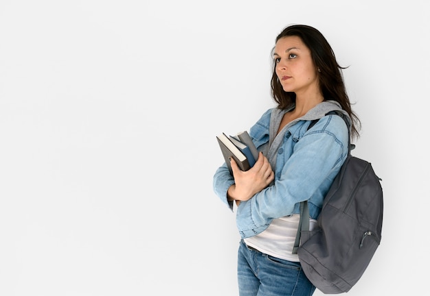 Une étudiante porte des livres et un sac à dos