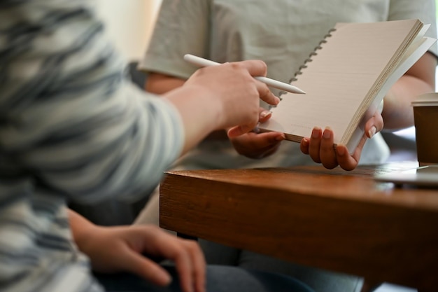 Photo une étudiante qui aide ses amis à faire leurs devoirs dans un café