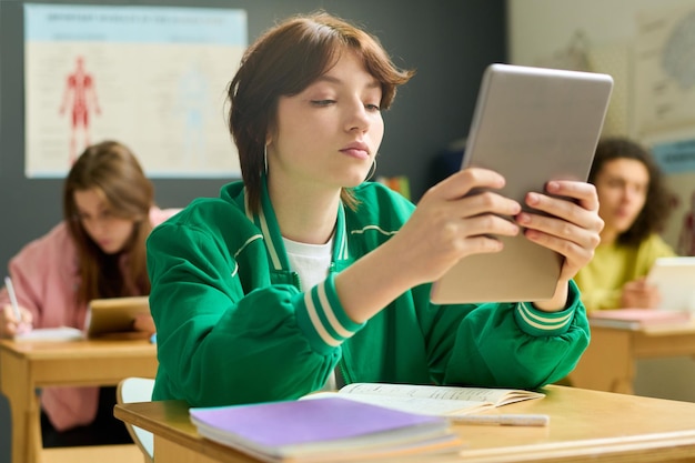 Étudiante Sérieuse Du Lycée Tenant Une Tablette Devant Son Visage