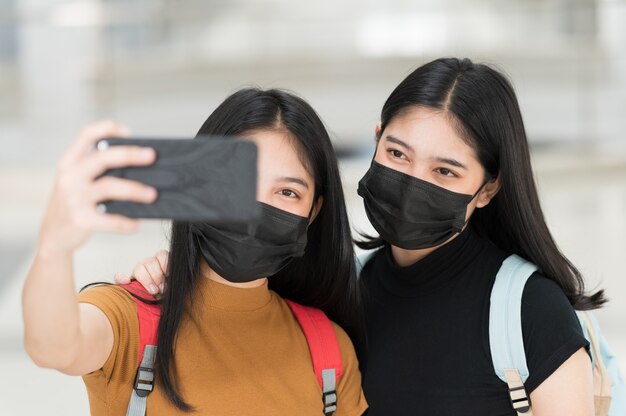 Une étudiante avec un téléphone prenant un selfie à l'université, retour à l'école,