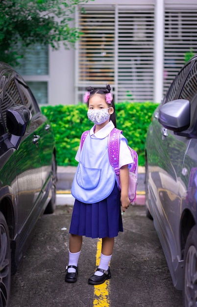 Photo une étudiante thaïlandaise portant un masque contre le coronavirus et la pollution atmosphérique pm 2,5 avant d'aller à l'école