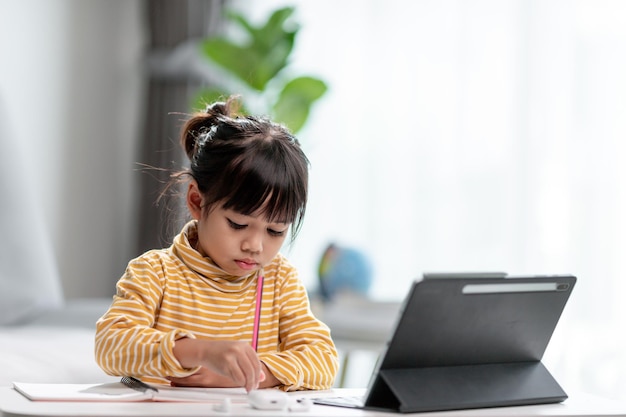 Des étudiantes asiatiques dans des cours d'apprentissage en ligne étudient en ligne avec une tablette à la maison