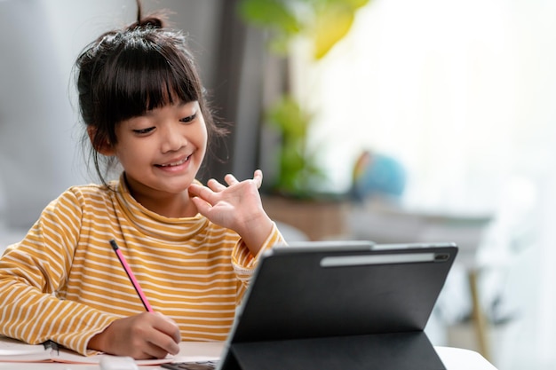 Des étudiantes asiatiques dans des cours d'apprentissage en ligne étudient en ligne avec une tablette à la maison