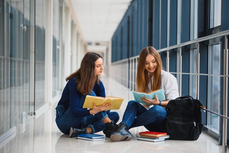 Étudiantes assises sur le sol et lisant des notes avant l'examen