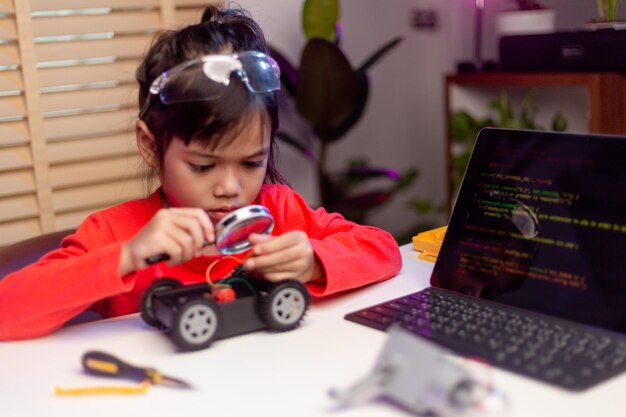 Les étudiants asiatiques apprennent à la maison à coder des voitures robotisées et des câbles de cartes électroniques dans STEM STEAM mathématiques ingénierie science technologie code informatique dans la robotique pour le concept des enfants