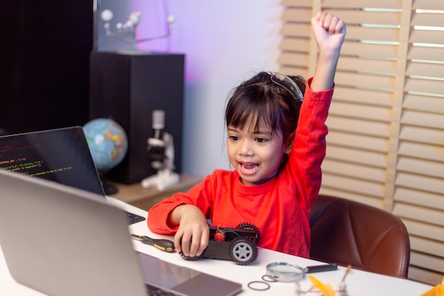 Les étudiants asiatiques apprennent à la maison à coder des voitures robotisées et des câbles de cartes électroniques dans STEM STEAM mathématiques ingénierie science technologie code informatique dans la robotique pour le concept des enfants