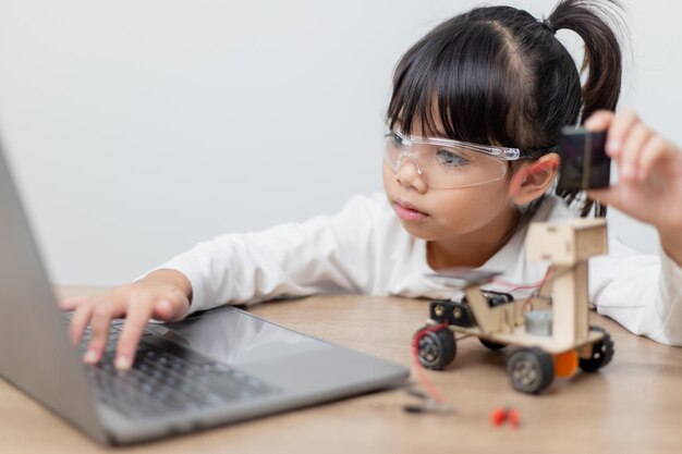 Les étudiants asiatiques apprennent à la maison à coder des voitures robotisées et des câbles de cartes électroniques dans STEM STEAM mathématiques ingénierie science technologie code informatique dans la robotique pour le concept des enfants