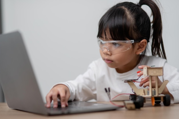Les étudiants asiatiques apprennent à la maison à coder des voitures robotisées et des câbles de cartes électroniques dans STEM STEAM mathématiques ingénierie science technologie code informatique dans la robotique pour le concept des enfants