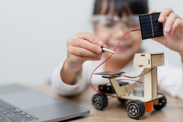 Photo les étudiants asiatiques apprennent à la maison à coder des voitures robotisées et des câbles de cartes électroniques dans stem steam mathématiques ingénierie science technologie code informatique dans la robotique pour le concept des enfants