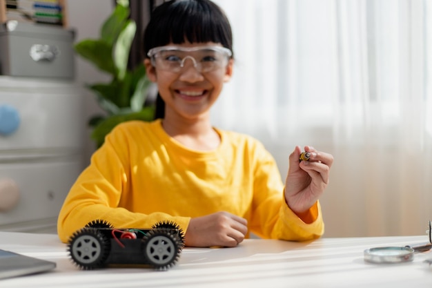 Les étudiants asiatiques apprennent à la maison à coder des voitures robotisées et des câbles de cartes électroniques dans STEM STEAM mathématiques ingénierie science technologie code informatique dans la robotique pour le concept des enfants