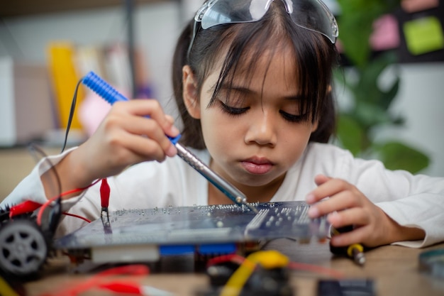 Les étudiants asiatiques apprennent à la maison à coder des voitures robotisées et des câbles de cartes électroniques dans STEM STEAM