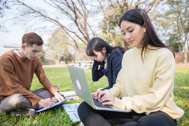 Les étudiants asiatiques utilisent des ordinateurs portables et des tablettes pour travailler et étudier en ligne dans le jardin à la maison pendant l'épidémie de coronavirus et la quarantaine à la maison