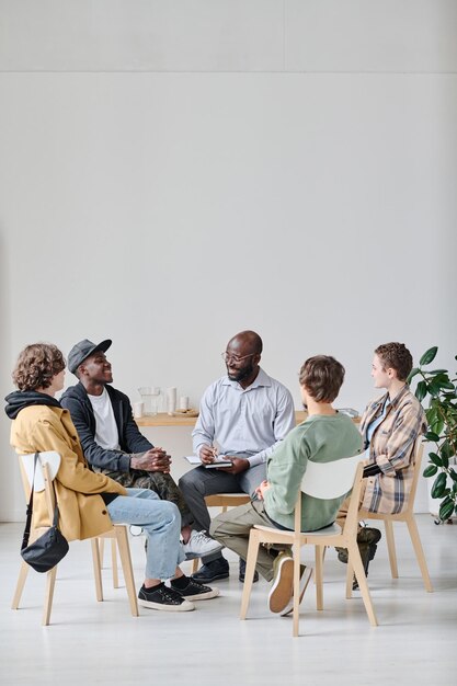 Étudiants avec entraîneur assis en classe