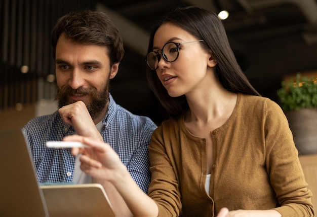 Les étudiants étudient, utilisent un ordinateur portable, travaillent en ligne. Collègues de travail regardant des cours de formation