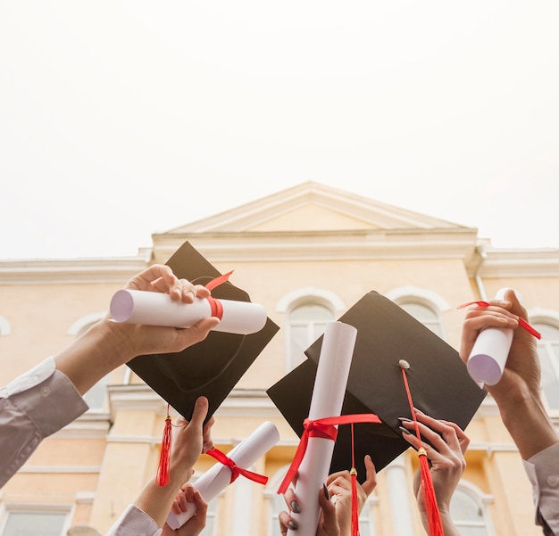 Photo Étudiants à faible angle avec diplôme