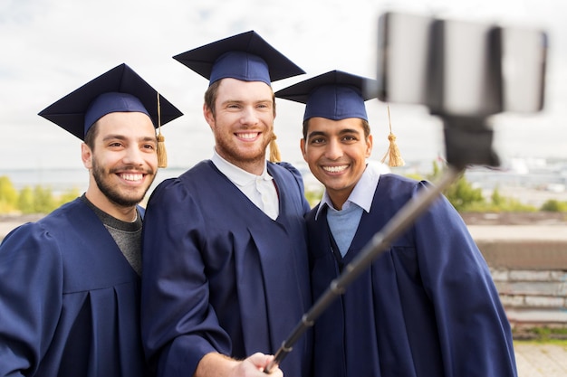 Des étudiants heureux qui prennent une photo avec un bâton de selfie.