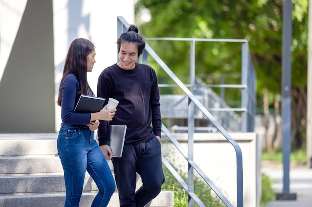 Les étudiants marchent dans les escaliers du campus, un couple descend dans le sol pour poursuivre ses études.