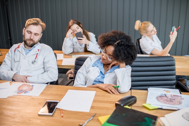 Photo Étudiants en médecine fatigués dormant pendant la leçon ennuyeuse en classe