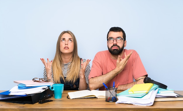 Des étudiants avec de nombreux livres frustrés par une mauvaise situation