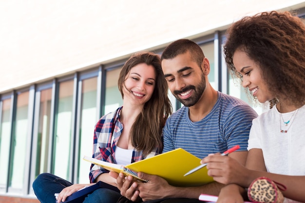 Étudiants partageant des notes sur le campus universitaire