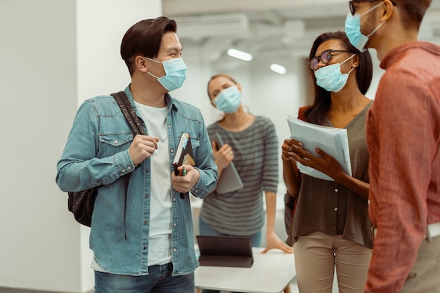 Photo des étudiants portant des masques de protection et se parlant